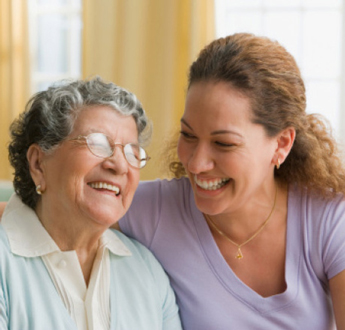 An older woman and a younger woman smile at each other