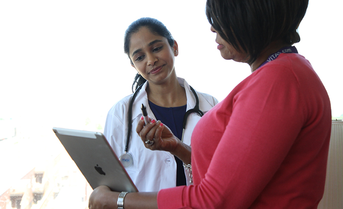 Two VITAS team members review information on an iPad