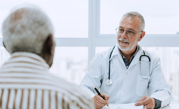 A physician talks to a patient in his office