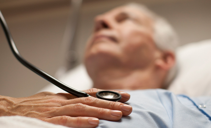 A clinician holds a stethoscope to a patient's chest